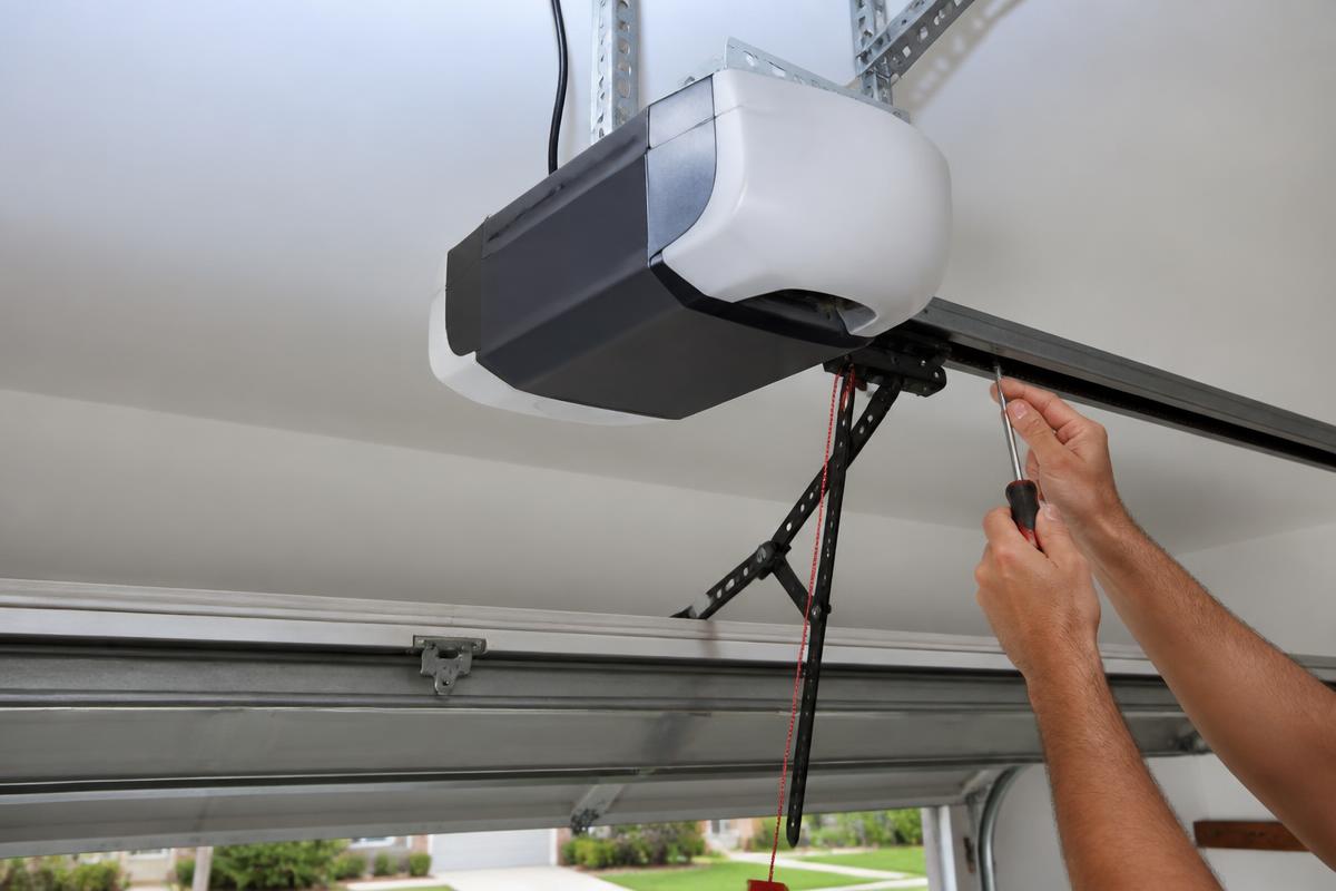 Technician performing garage door opener repair in a Tega Cay, SC home garage